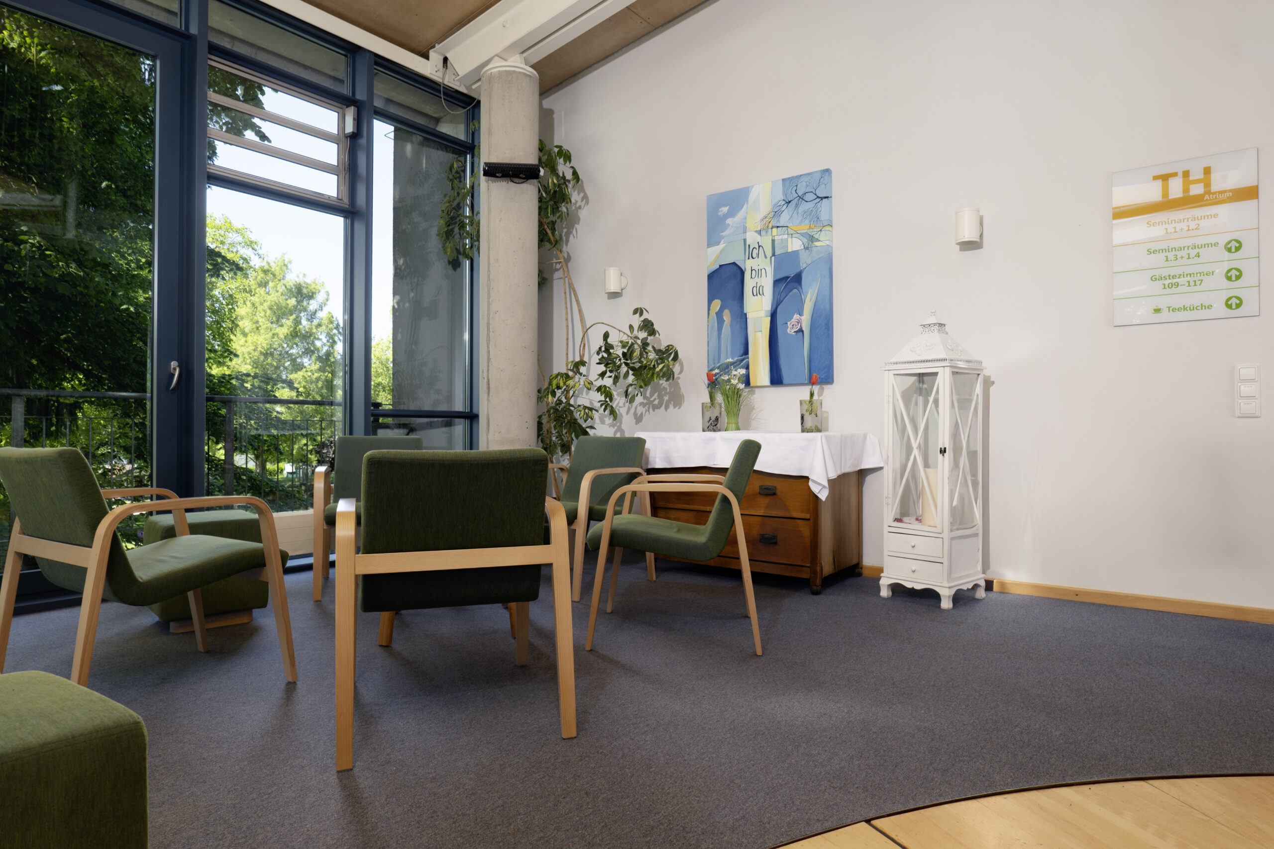 Tagungsteatte-Sitzgruppe Sitzecke im Foyer mit Korbstühlen und Ausblick in den Garten